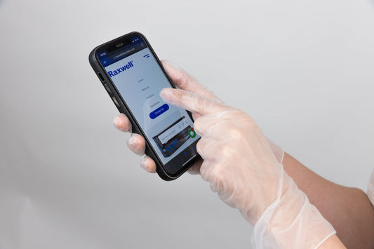 Person holding a phone while wearing clear vinyl gloves