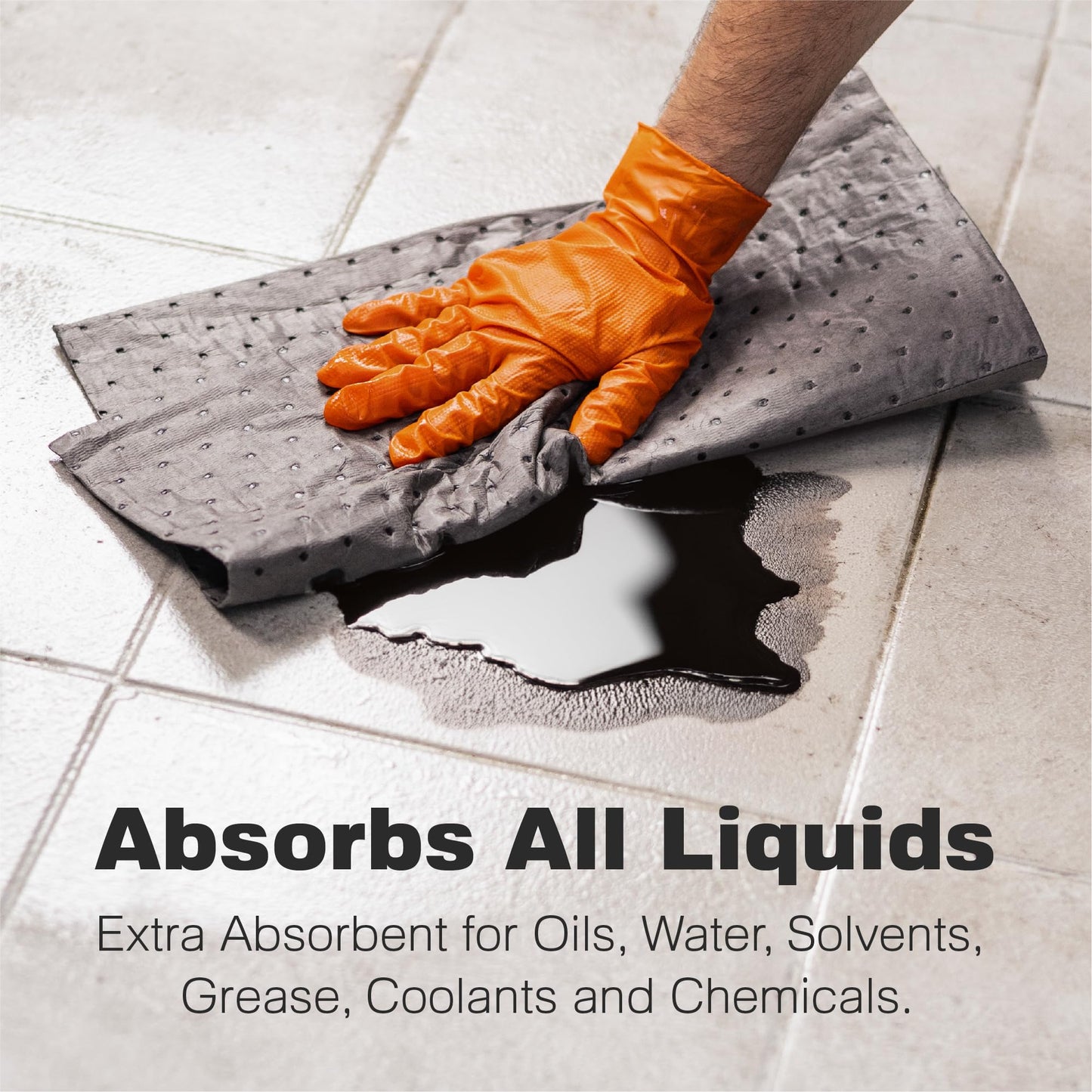 A gloved hand uses an absorbent pad to soak up a dark liquid spill on a tiled floor. The text reads: Absorbs All Liquids. Extra absorbent for oils, water, solvents, grease, coolants and chemicals.